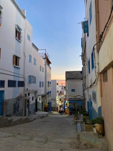 an alley with white buildings in a city at sunny wave taghazout SURF & YOGA in Taghazout