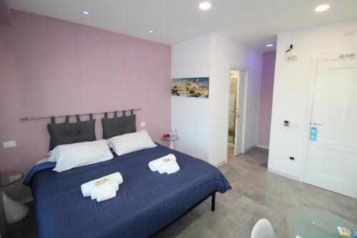 Un dormitorio con una cama azul con toallas. en Ri.Mo's Rent Room, en Palermo