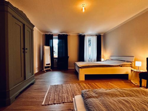 een slaapkamer met 2 bedden en een groot raam bij Gemütliche Ferienwohnung in Uelzen mit eigenem Garten in Uelzen
