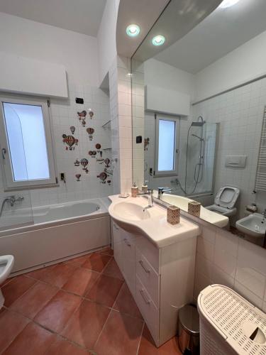 a bathroom with a sink and a tub and a toilet at Brendon Suite in Brindisi