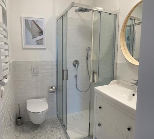 a bathroom with a shower and a toilet and a sink at Family Apartments Portova in Gdynia