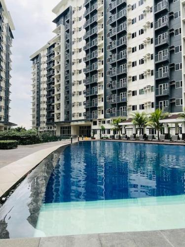 uma grande piscina em frente a um grande edifício de apartamentos em 2 BR SMDC Vine Residences em Manila