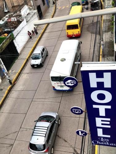 dos autobuses y coches estacionados en una calle de la ciudad en Hotel Los Chankas, en Ayacucho