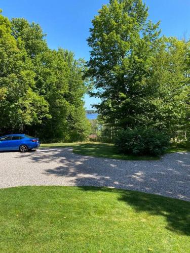 a blue car parked in a parking lot with trees at Rustic U.P. Retreat in Marquette in Marquette