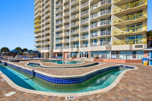 a large apartment building with two pools in front of it at Bay Watch Resort in Myrtle Beach