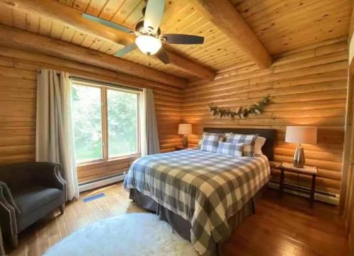 - une chambre avec un lit et un ventilateur de plafond dans l'établissement Rustic U.P. Retreat in Marquette, à Marquette