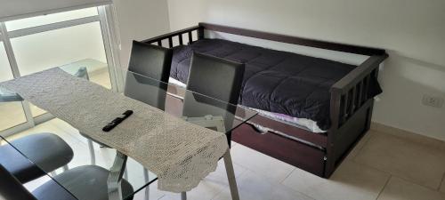 a small bedroom with a glass table and a bed at Tu Destino in Colón