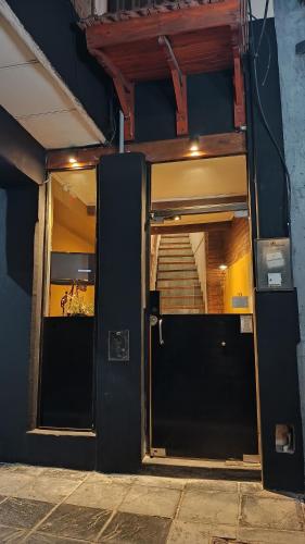 an open door of a building with a staircase at Hostería Suites Del Centro in Santa Rosa de Calamuchita