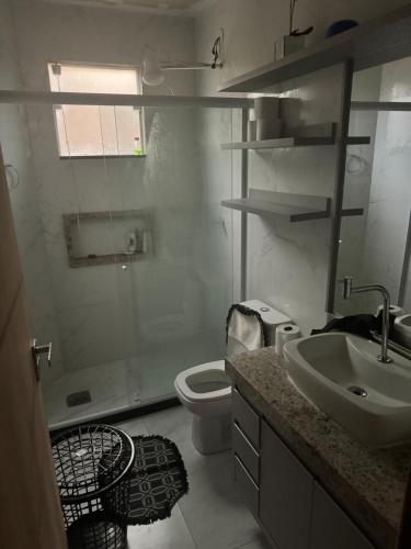 a white bathroom with a sink and a toilet at Casa 3 quartos portinho Cabo Frio in Cabo Frio