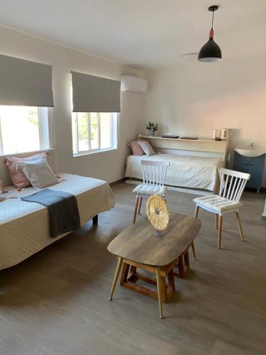 a bedroom with two beds and a table and chairs at Casa Guemes in Santiago