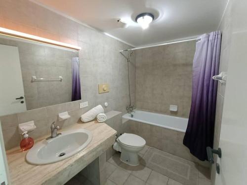 a bathroom with a sink and a toilet and a tub at Comfy house on a hidden beach in Five Islands Village