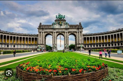 un gran edificio con un gran arco con flores delante en Élégant appartement (quartier européen) en Bruselas