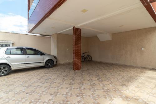 un coche blanco aparcado en un garaje vacío en Casa nova condomínio fechado Praia Grande SP en Solemar