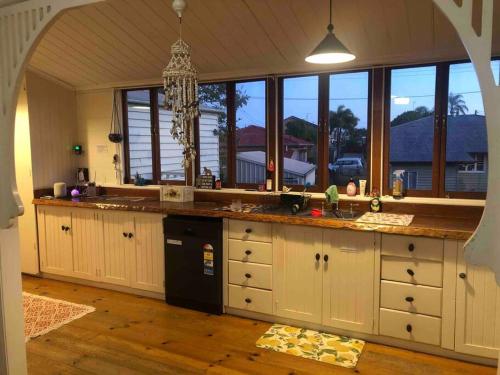 eine Küche mit weißen Schränken und einem großen Fenster in der Unterkunft Free Wi-fi, spacious, Netflix. Long term discount in Bundaberg