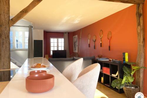 un salon avec un mur d'accent orange dans l'établissement Le Duplex - Parking - Vue Clochers - Tennis, à Rouen