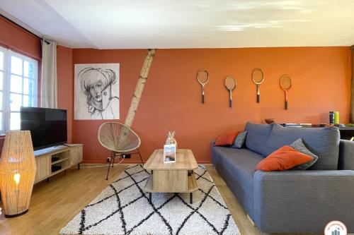 - un salon avec un canapé bleu et un mur avec des horloges dans l'établissement Le Duplex - Parking - Vue Clochers - Tennis, à Rouen