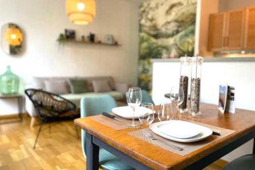 une table en bois avec des assiettes et des verres à vin dessus dans l'établissement Hôtel Turgot - Ancien hôtel particulier - Lumineux, à Rouen