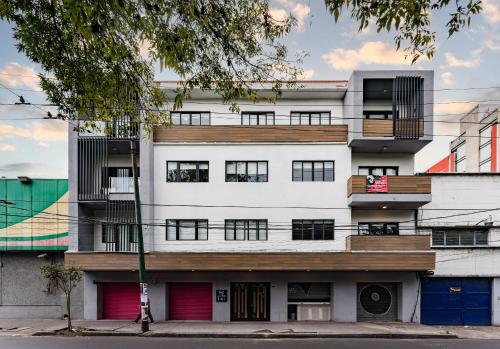 a white building with red doors and windows at Lofts & apartments Near Polanco by VH in Mexico City