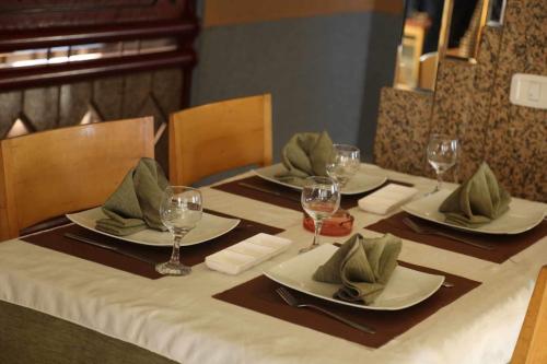 a table with four plates and wine glasses on it at Hotel Amine in Sfax