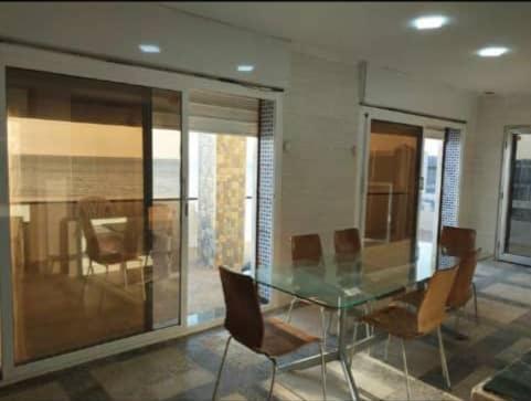 una sala da pranzo con tavolo in vetro e sedie di Villa Marame a Bordj el Bahri