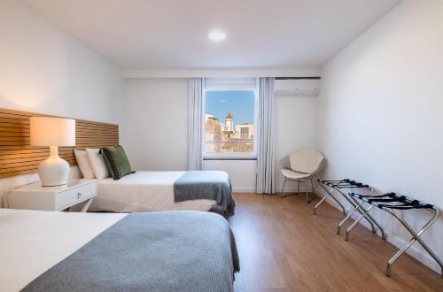een hotelkamer met 2 bedden en een raam bij Ponta Delgada Flats - HOST & CHILL in Ponta Delgada