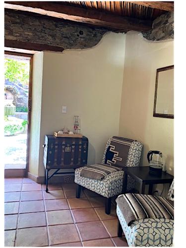 a living room with two chairs and a table at Hotel Amor y Paz in Real de Catorce