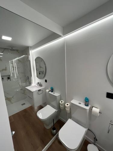 La salle de bains blanche est pourvue de toilettes et d'un lavabo. dans l'établissement Luxury View Apartment Funchal, à Funchal