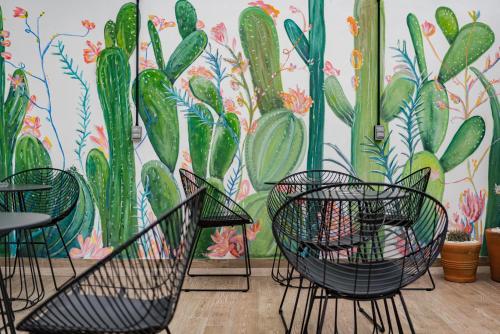 a room with chairs and a mural of cactus at Mariano Escobedo Apartments by VH in Mexico City
