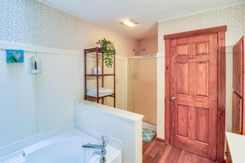 bagno con vasca e porta in legno di Charming Newark Home Less Than 10 Mi to Buckeye Lake a Newark