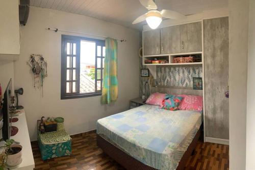 ein Schlafzimmer mit einem Bett und einem Fenster in der Unterkunft Refúgio perto do Mar: Ótima casa a 350m da praia in Pontal do Paraná