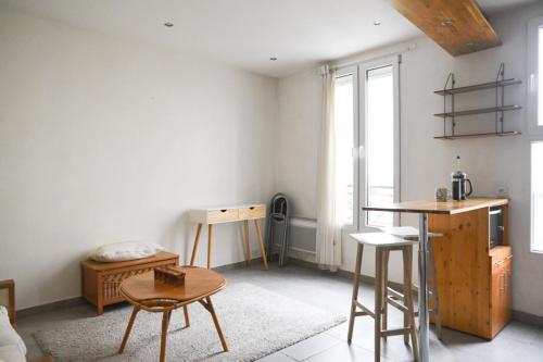 a living room with a table and some chairs at Pleasant love cocoon of 30 m in Clichy in Clichy