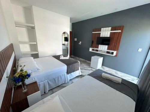 a hotel room with a bed and a tv at WL IMPERIO HOTEL POUSADA in Canoa Quebrada
