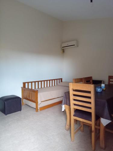 1 dormitorio con 1 cama, mesa y sillas en La Tata en Alta Gracia