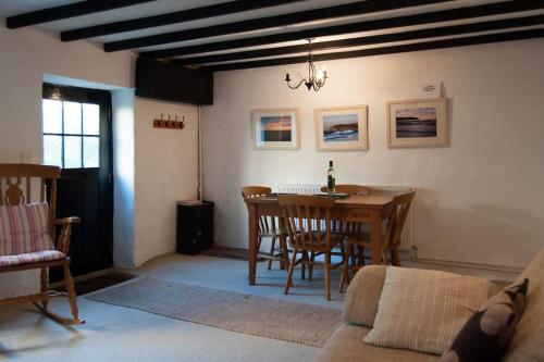 a living room with a table and chairs and a couch at Cosy private cottage near beach in Ilfracombe