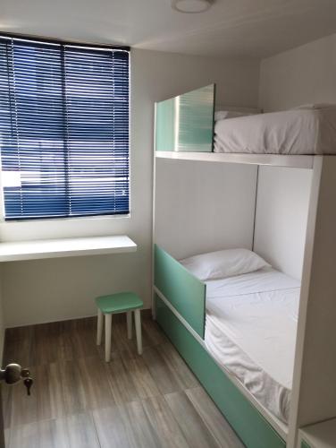Cette petite chambre comprend des lits superposés et une fenêtre. dans l'établissement apartamento cerca al aeropuerto parqueadero privado conjunto cerrado bilbao, à Cúcuta