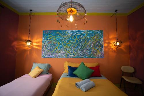 two beds in a room with a painting on the wall at Soul - moradia criativa in Vila Franca de Xira