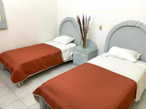 dos camas sentadas una al lado de la otra en una habitación en Meson la Esperanza, en Lagos de Moreno