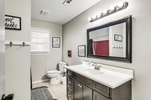 a bathroom with a sink and a toilet and a mirror at Mount Pleasant Home with Yard, Sunroom and Game Room! in Charleston