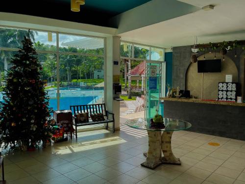 a christmas tree in a living room with a table at Hotel Puente Nacional & Spa in Puente Nacional