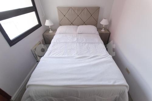 a bedroom with two beds with white sheets and a window at Amazing Apartment Near La Costanera in Asunción