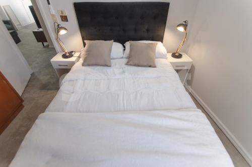 ein Schlafzimmer mit einem großen weißen Bett mit zwei Lampen in der Unterkunft Amazing Apartment Near La Costanera in Asunción