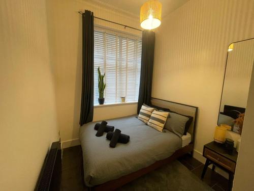 a bedroom with a bed with a window and a plant at Castaway Liverpool Weekly Stays in Liverpool