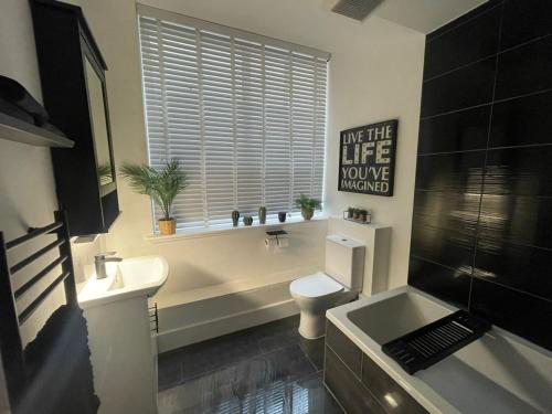uma casa de banho com um WC, um lavatório e uma banheira em Castaway Liverpool Weekly Stays em Liverpool