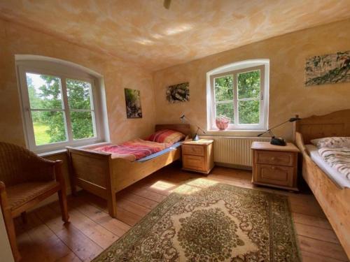 a bedroom with two beds and a chair and two windows at Erholen und Wohlfühlen Auf dem Knick in Detmold