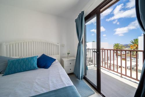 a bedroom with a bed and a balcony at Casa de los Belges in Yaiza