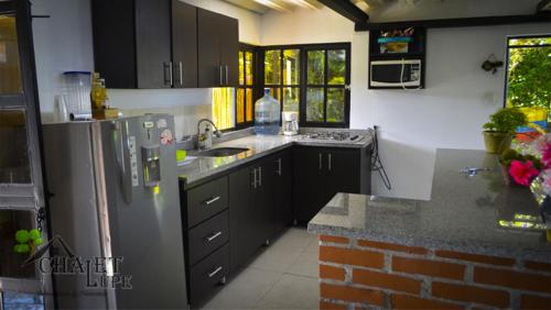 a kitchen with a refrigerator and a sink in it at Chalet Lupe in Palestina