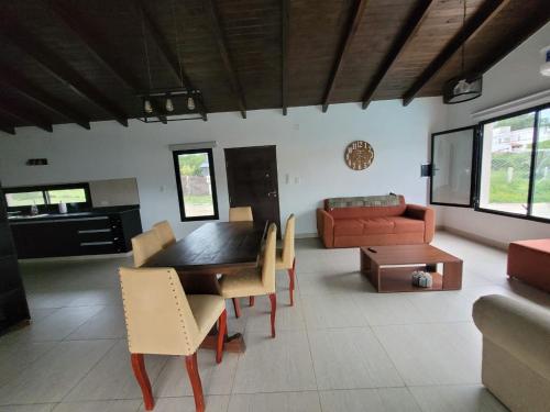 a living room with a table and chairs and a couch at Casa con pileta en Vaqueros in Vaqueros