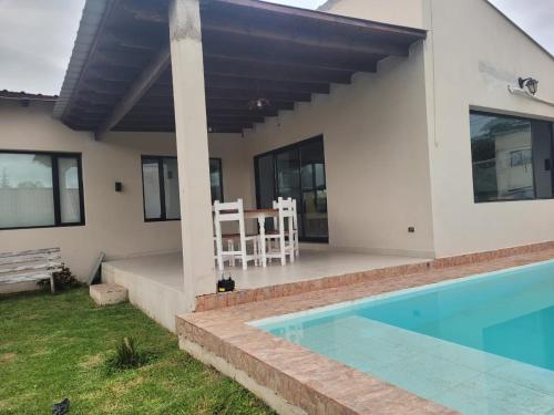 a villa with a swimming pool and a house at Casa con pileta en Vaqueros in Vaqueros