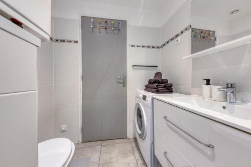 uma casa de banho branca com uma máquina de lavar roupa e um lavatório em Central 3 - 10 min Paris - 30 min Disney - Free Parking - 5 min RER A em Fontenay-sous-Bois