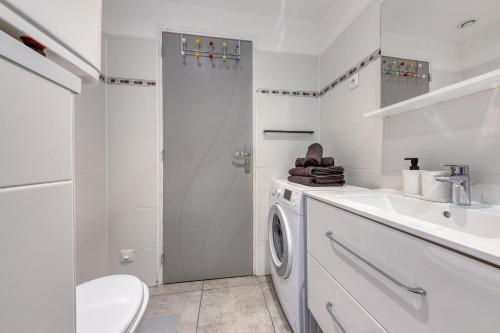 a white bathroom with a washing machine and a sink at Central 3 - 10 min Paris - 30 min Disney - Free Parking - 5 min RER A in Fontenay-sous-Bois